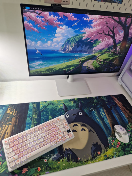 Setup de gaming cu mousepad cu personaj inspirat din Ghibli - Totoro. Mouse si tastatura si un peisaj din natura.