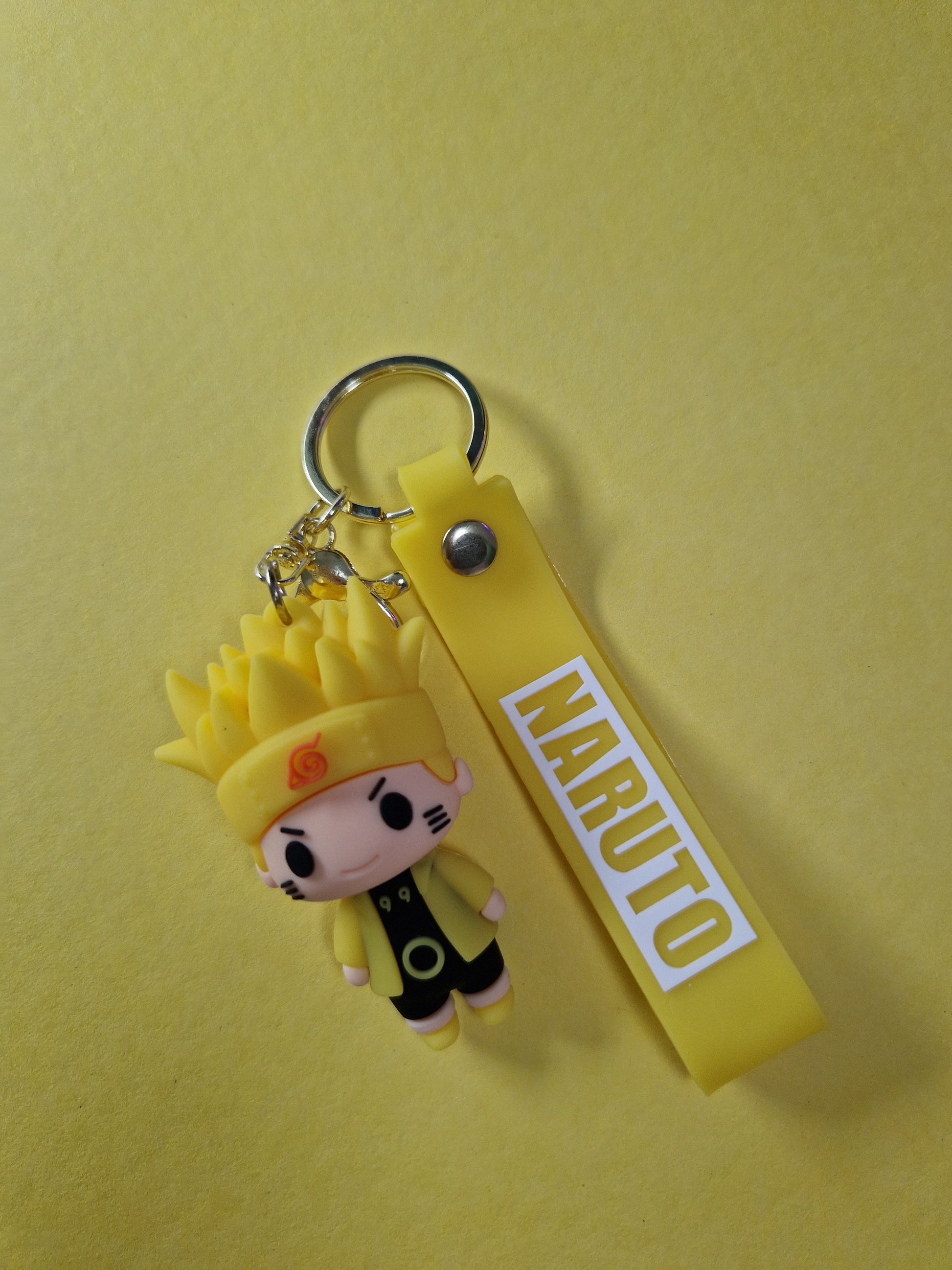 Breloc cu Naruto Uzumaki in varianta galbena pe fundal galben