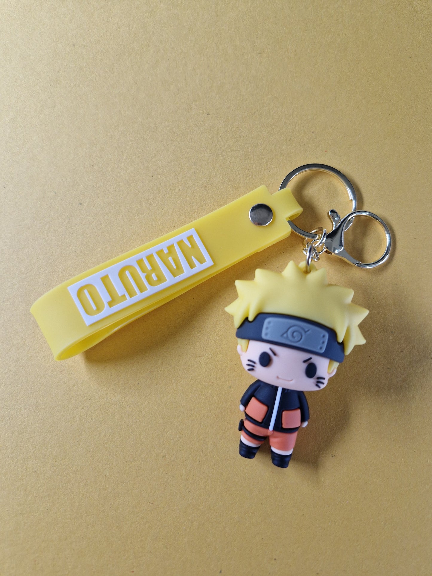 Breloc cu Naruto Uzumaki in varianta portocalie pe fundal galben