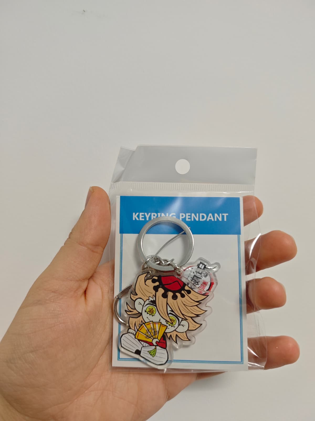 Breloc cu personajul Doma din Demon Slayer in ambalaj