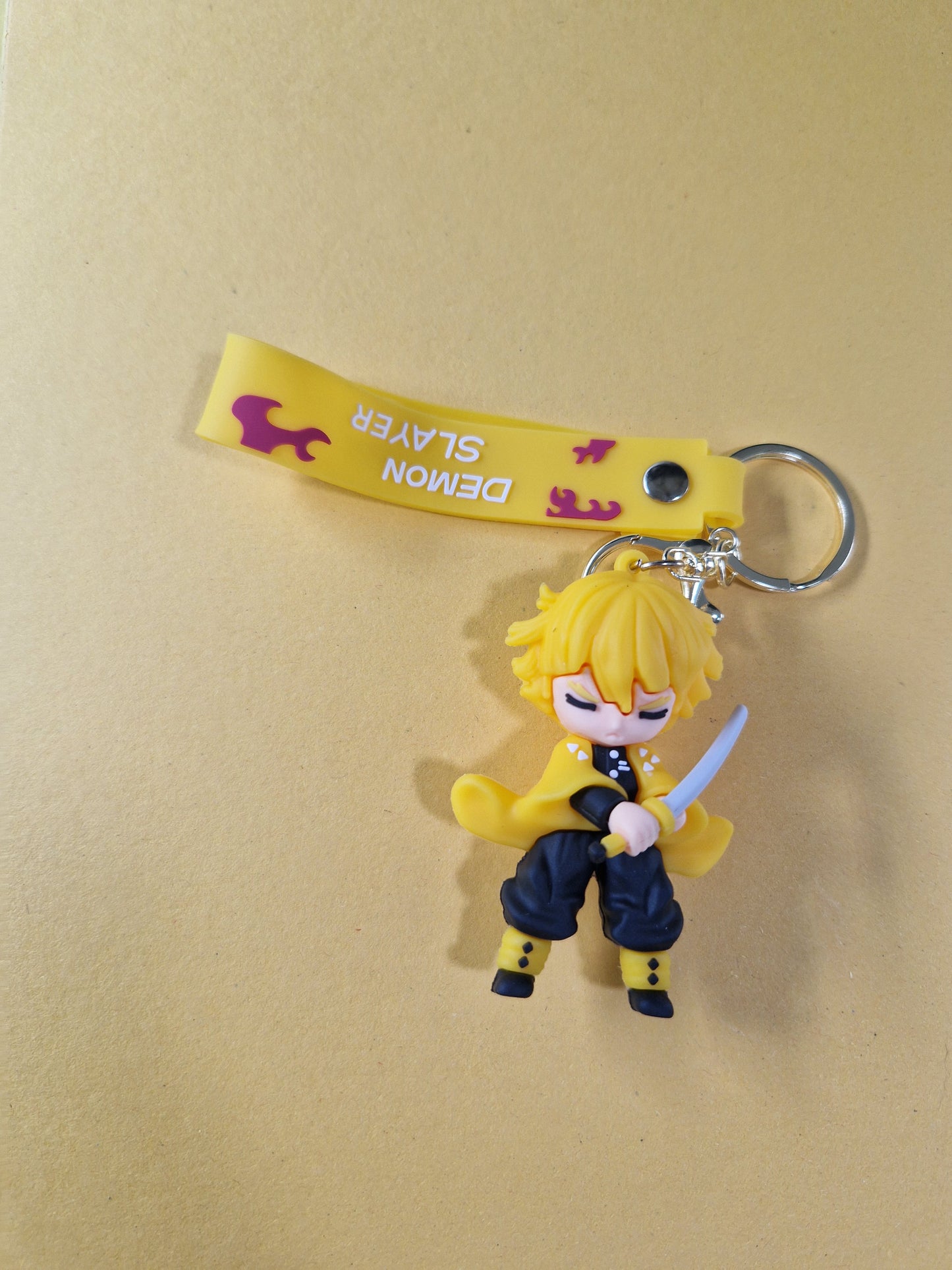 Breloc cu Zenitsu din Demon Slayer pe fundal bej