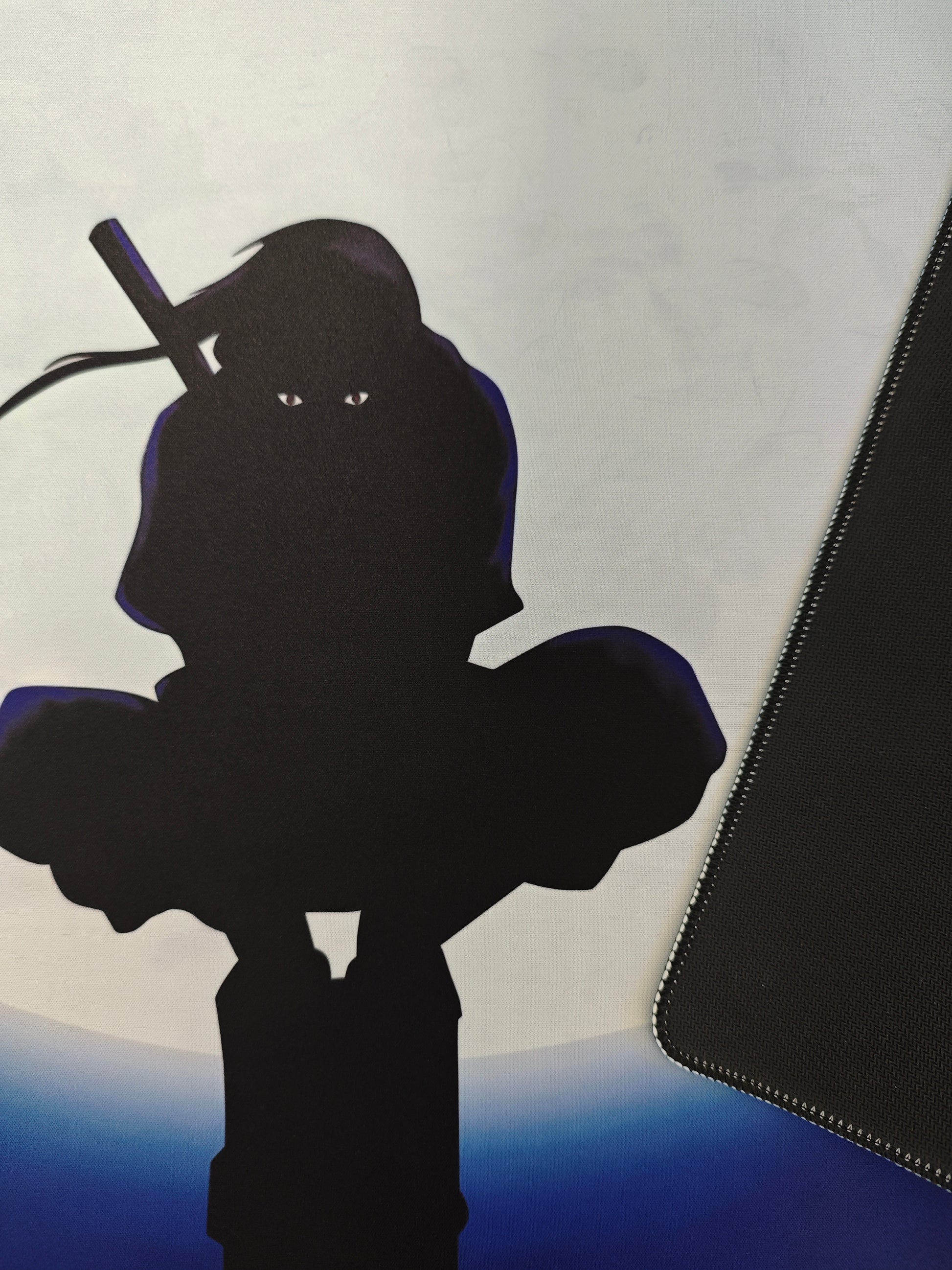 Mousepad gaming Naruto cu personajul Itachi pe birou cu detaliu pe baza de cauciuc.