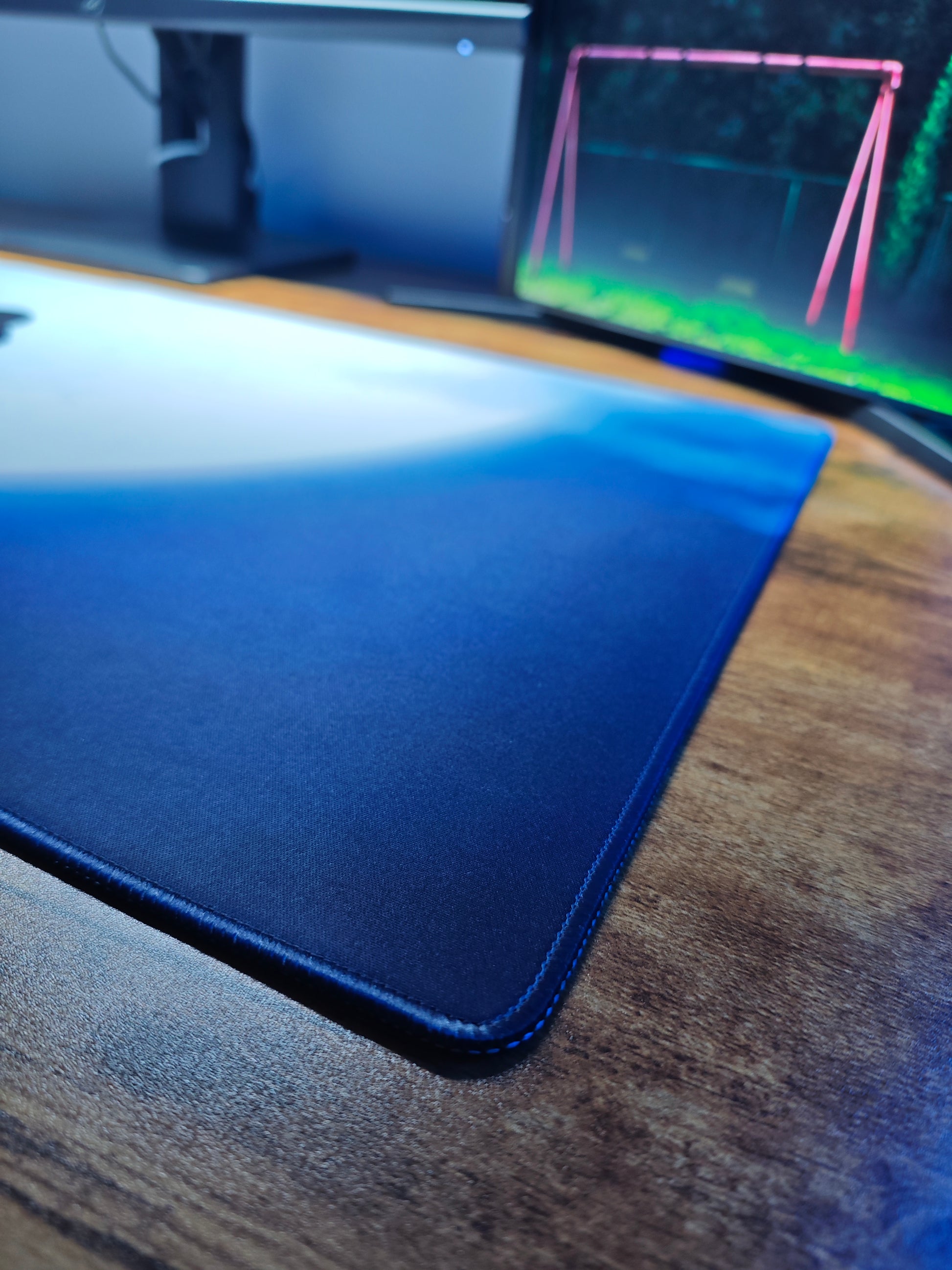 Mousepad gaming Naruto cu personajul Itachi pe birou cu detaliu pe marginea cusută.