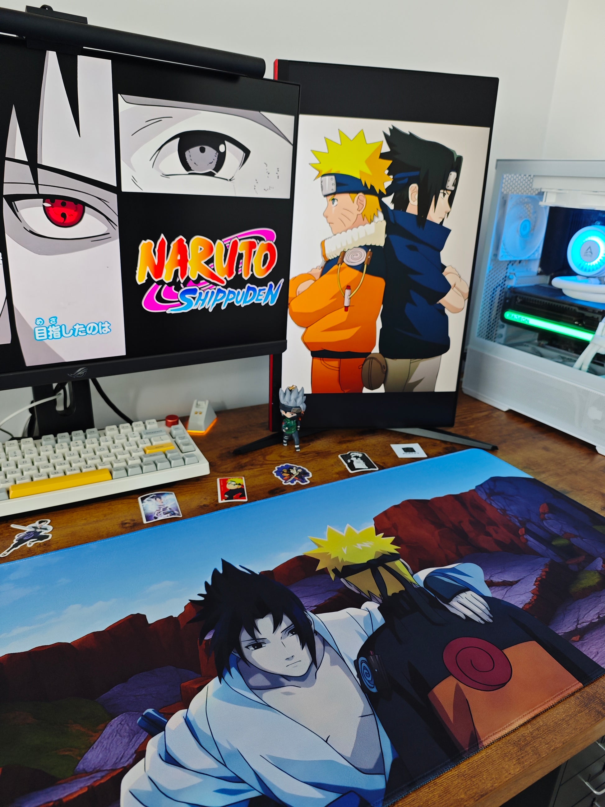 Mousepad Naruto și Sasuke pe un birou de gaming cu tastatură mecanică și PC.