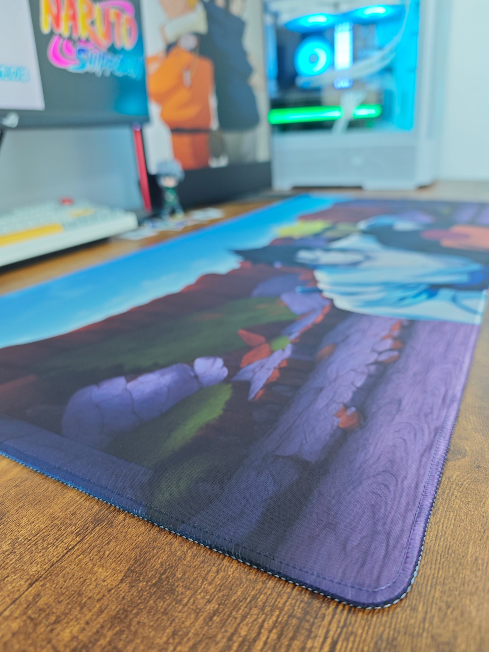 Mousepad gaming Naruto și Sasuke pe birou cu detaliu pe marginea cusută.